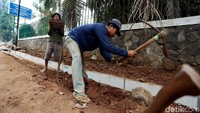 Sejumlah pekerja tengah menyelesaikan pembuatan saluran air.