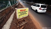 Papan pemberitahuan dari Dinas Binamarga Jakarta Timur terlihat nampang di sisi jalan.