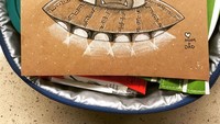 Gambar alien lengkap dengan ufo menghiasi selipan kertas di atas bekal makanan.