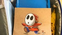 Ia pun sudah membuat beberapa gambar pada 10 hari pertama anak laki-lakinya masuk TK. Pada gambar tak ketinggalan tanda hati dan tulisan mom + dad.