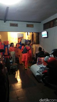 warga mengangkat barang-barang di kediamannya