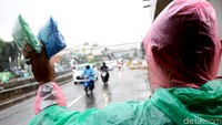 Seorang pedagang jas hujan keliling saat menawarkan dagangannya di kawasan Jatinegara, Jakarta, Kamis (12/10/2017).