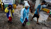 Beberapa anak nampak mengenakan jas hujan ketika pulang dari sekolah.