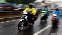 Sejumlah pengendara motor nampak menerobos derasnya hujan.