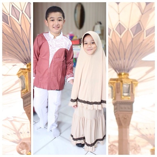 Eisha memakai setelan gamis dengan detail renda yang sempat tren di kalangan hijabers muda Indonesia. Khimar syari dengan tambahan pet juga cocok dipakai anak-anak. Pilih warna yang cerah agar anak tampil segar. Foto: Dok. Instagram @lyravirna