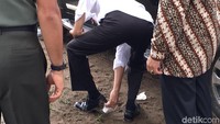 Setelah menempuh jarak sekitar 1,8 kilometer, mobil yang ditumpangi Jokowi tiba di landasan helikopter. Saat pintu dibuka, Jokowi tampak tertunduk-tunduk melirik ke arah sepatunya.  Foto: Jordan/detikcom