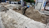 Pekerja mengerjakan pembangunan trotoar ramah disabilitas di Jalan Dewi Sartika.