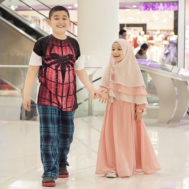 Gaya hijab syari Eisha berwarna peach ini cocok dipakai ke segala acara. Eisha mencoba berhijab syari saat pergi ke mal bersama sang kakak. Foto: Dok. Instagram @lyravirna