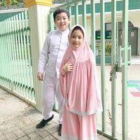 Kali ini Eisha tampil manis mengenakan hijab syari warna merah muda. Sentuhan renda putih pada bagian bawah gamis dan khimarnya membuat penampilan terlihat segar.  Foto: Dok. Instagram @lyravirna