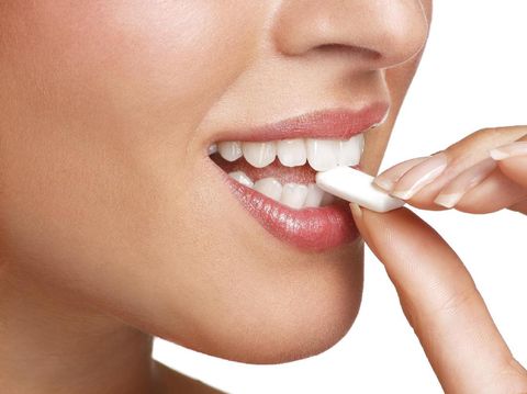Woman holding model of human intestines in front of body on white background. Female hands showing artificial model of lower human tissue and organs in front of body. The plastic model is isolated on shirt as white background. This model shows the real size of this part of the body, it is used in high school to teach teens biology and science.
