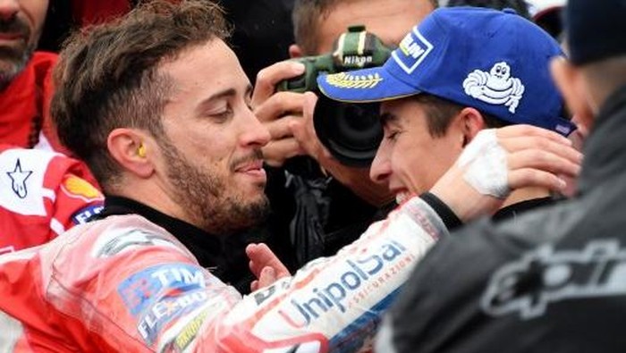 Ducati rider Andrea Dovizioso of Italy (L) is congraturated by Honda rider Marc Marquez of Spain (R) at the parc ferme during the MotoGP Japanese Grand Prix at Twin Ring Motegi circuit in Motegi, Tochigi prefecture on October 15, 2017. / AFP PHOTO / TOSHIFUMI KITAMURA