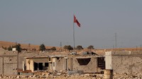 Bendera Turki berkibar di perbatasan Turki dan Suriah di Kobani, tak jauh dari lokasi anak-anak bekerja sebagai kuli bangunan (Dok. REUTERS/Erik De Castro)