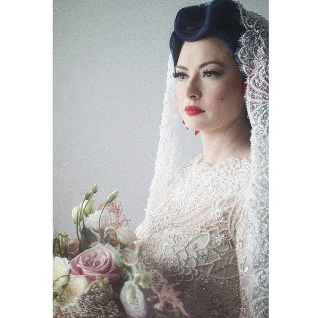 Claudia Adinda tidak menanggalkan karakter sebagai gadis pin up ala tahun 40-an ketika menikah dengan aktor dan penyanyi Derby Romero. Di hari besarnya, ia pun tampil unik lengkap dengan makeup dan tatanan rambut yang populer di era 40 hingga 70-an tersebut. Foto: Dok. Instagram