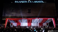 Warga mengabadikan pidato Anies-Sandi di acara Selamatan Jakarta.