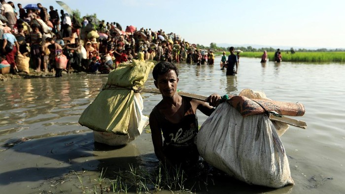 Pengungsi Rohingya yang melarikan diri dari Myanmar berjuang untuk melewati perbatasan di Palang Khali, Bangladesh. (16/10/2017)