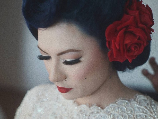 Pengantin wanita tampil ala gadis pin up dengan riasan berat karya LaOde Yusuf yang fokus pada pulasan bibir merahnya. Foto: Dok. Instagram