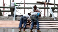 Beberapa pekerja juga tampk sedang memasang rangka di bagian atap. 