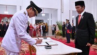 Sandiaga menandatangani berita acara pelantikan dengan disaksikan Jokowi. Pool/Setpres.