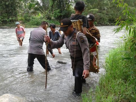 Heroik! Viral Polisi Pribumi Gendong Warga Sakit di Pedalaman Sulteng