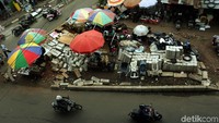 Para PKL menggelar dagangan di antara tumpukan material bangunan.