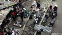 Mereka tetap berjualan meski trotoar tersebut sedang diperbaiki.