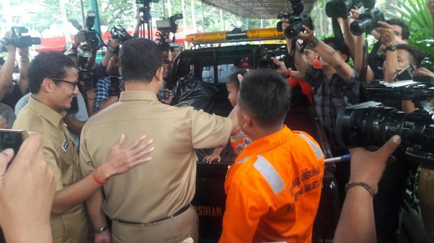 Anies dan Sandi menyapa petugas kebersihan yang sedang membersihkan halaman  Balai Kota.