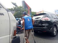 Wilem dibantu dua kruk saat berjualan koran