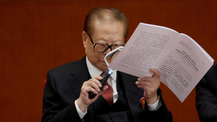 Former Chinese President Jiang Zemin uses a magnifier as he reads Chinese President Xi Jinpings report during the opening of the 19th National Congress of the Communist Party of China at the Great Hall of the People in Beijing, China October 18, 2017. REUTERS/Jason Lee     TPX IMAGES OF THE DAY