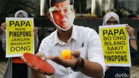 Aktivis antikorupsi yang memakai topeng bergambar Novanto melakukan servis.