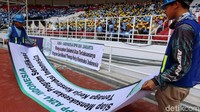 Pekerja menurunkan spanduk usai proses sertifikasi yang dilakukan di GBK.