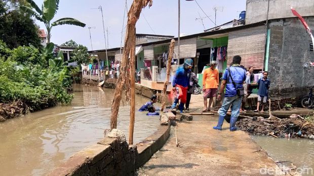  Petugas memperbaiki tanggul karung jebol di Kali Pulo, Jatipadang, Jakarta Selatan