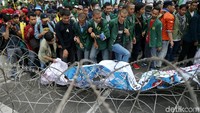 Massa menginjak-injak kawat berduri yang di pasang di depan Istana.
