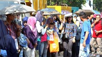 Hari semakin siang, warga pun sedia payung.