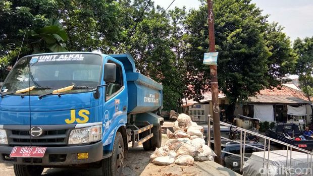  Petugas memperbaiki tanggul karung jebol di Kali Pulo, Jatipadang, Jakarta Selatan