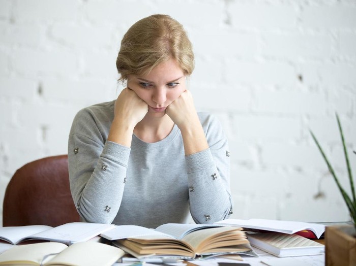 Portrait of a tired student woman sitting at the desk, lifestyle. Education concept photo