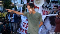 Dalam aksi teatrikal itu seorang peserta aksi memakai topeng bergambar Jokowi.