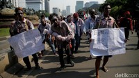 Mereka tampil dengan kompak berpenampilan ala zombie sambil melakukan long march.