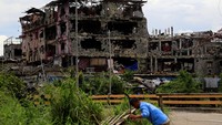 Bangunan-bangunan yang tak runtuh tampak dindingnya berlubang (REUTERS/Romeo Ranoco)