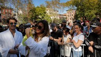 Seorang wanita memegangi anjingnya yang berpakaian seperti bebek karet (REUTERS/Lucas Jackson)