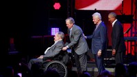 Momen menyentuh lainnya adalah saat Bush (junior) mendorong sang ayah yang duduk di kursi roda./Foto: REUTERS/Richard Carson