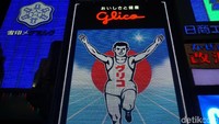Para wisatawan ini akan berusaha meniru pose legendaris dari si Glico Man. Merentangkan tangan, sembari mengangkat satu kaki, serta ekspresi kemenangan yang begitu ikonik (Wahyu/detikTravel)