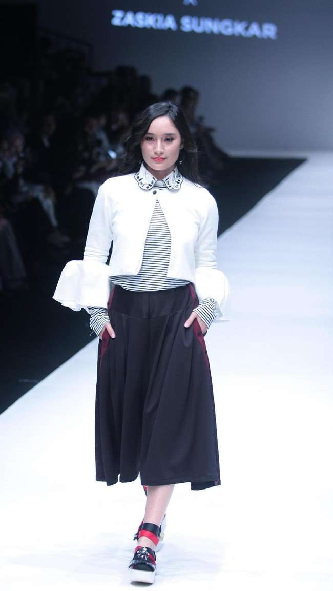 Tatjana Saphira berjalan di atas runway mengenakan rancangan Zaskia Sungkar berupa setelan celana kulot hitam, striped blouse, dan bell sleeve outerwear. Rancangan terbaru Zaskia Sungkar yang bertajuk Hue Pops itu tampil di acara Color Euphoria persembahan Wardah. Foto: Dok.Mohammad Abduh/Wolipop