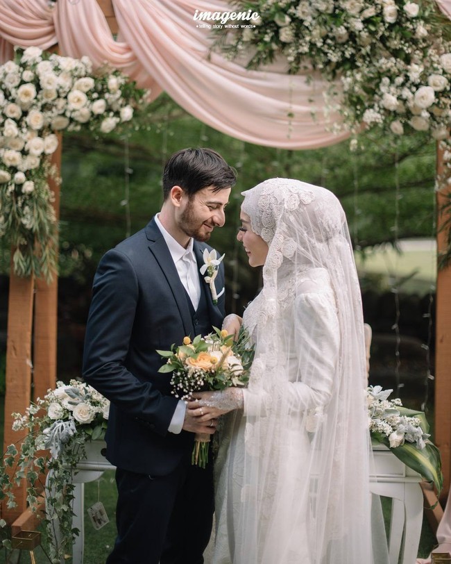 Ketika resepsi pernikahan, Irvan Farhad yang awalnya memakai beskap berganti menggunakan jas. Penampilannya menyeimbangkan gaun putih Hamidah Rachmayanti. Foto: Dok. Instagram @imagenic