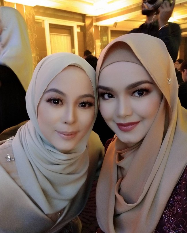 Ini penampilan cantik Siti Nurhaliza yang memakai kerudung satin saat selfie bersama pengusaha muda berhijab Vivy Yusof. Kali ini Siti Nurhaliza memulaskan lipstik merah sesuai dengan bajunya. Foto: Dok. Instagram @ctdk