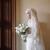 Sentuhan material lace dan veil panjang yang di letakkan di atas kerudung simpel membuat penampilan Hamidah Rachmayanti tampak anggun. Busana pengantin Hamidah Rachmayanti saat menikah dengan Irvan Farhad bisa menjadi inspirasi hijabers yang suka pesta pernikahan simpel. Foto: Dok. Instagram @imagenic