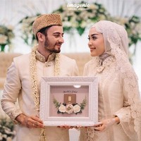Hamidah Rachmayanti menikah dengan Irvan Farhad di Rancamaya Golf & Country Club, Bogor, Sabtu (21/10/2017). Ketika akad nikah, baik selebgram 23 tahun ini dan pria yang dikabarkan pernah dekat dengan penyanyi dangdut Cita Citata itu mengenakan baju bernuansa putih. Hamidah memilih gaya hijab yang sederhana tapi klasik. Foto: Dok. Instagram @imagenic