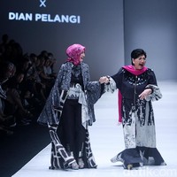 Yang paling menarik perhatian di runway adalah hadirnya penyanyi senior Titiek Puspa di runway JFW 2018. Wanita 79 tahun itu tampil segar bersama Ineke Koesherawati mengenakan rancangan Dian Pelangi yang bernuansa monokrom.  Foto: Dok. Mohammad Abduh/Wolipop