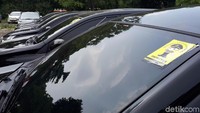 Taksi-taksi online ini ditempel stiker di bagian kaca depan dan belakang. Di bagian depan ada stiker berwarna kuning dengan gambar karikatur polisi bertuliskan Promoter dan Inkopol.