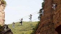 Berpose di atas jembatan tali, mereka menunjukkan keahliannya menjaga keseimbangan. (Foto: Facebook)