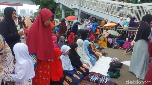 Massa perempuan ikut salat zuhur di sekitar lokasi